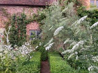White Garden with clipped borders of box framing brick herringbone pathways