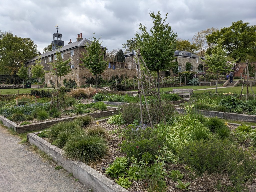 Gardens at Beckenham Place Park, with the old stable block in the background, April 2024