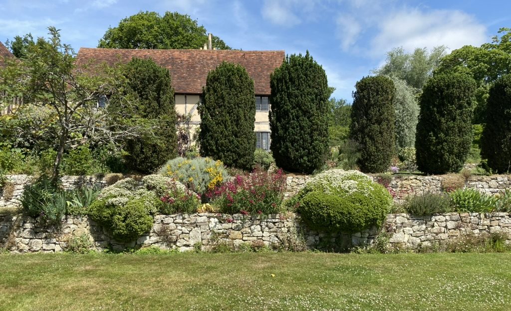 One of the terraces at Long Barn Gardens, with Vita’s conifers standing behind. June 2025