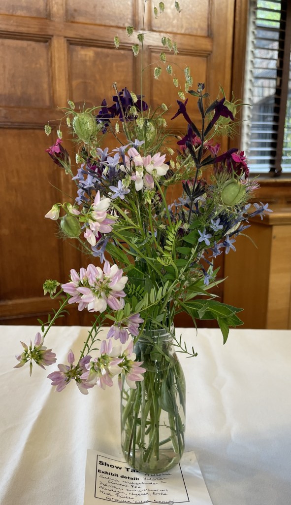 A delicate arrangement of flowers and grasses on the Show Table, June 2026